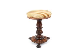 An Edwardian adjustable walnut piano stool, with flared walnut base supported on three lion pad