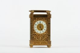 A 19th century French brass carriage clock, with enamel circular dial, pierced foliate grilles
