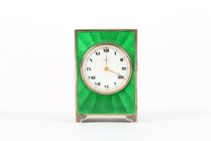 A 1920s Asprey guilloché enamel miniature bedroom clock, the bright green enamel and white metal