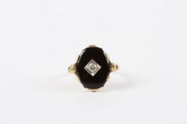 A gold coloured metal onyx and diamond ring, in oval setting In good condition