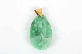 A Modern Chinese jade oval shaped pendant, carved with lotus leaf blossom, with suspension loop. 4.