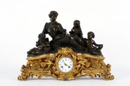 A large French bronze and gilt metal mantel clock, circa 1850, surmounted by a figural group of a