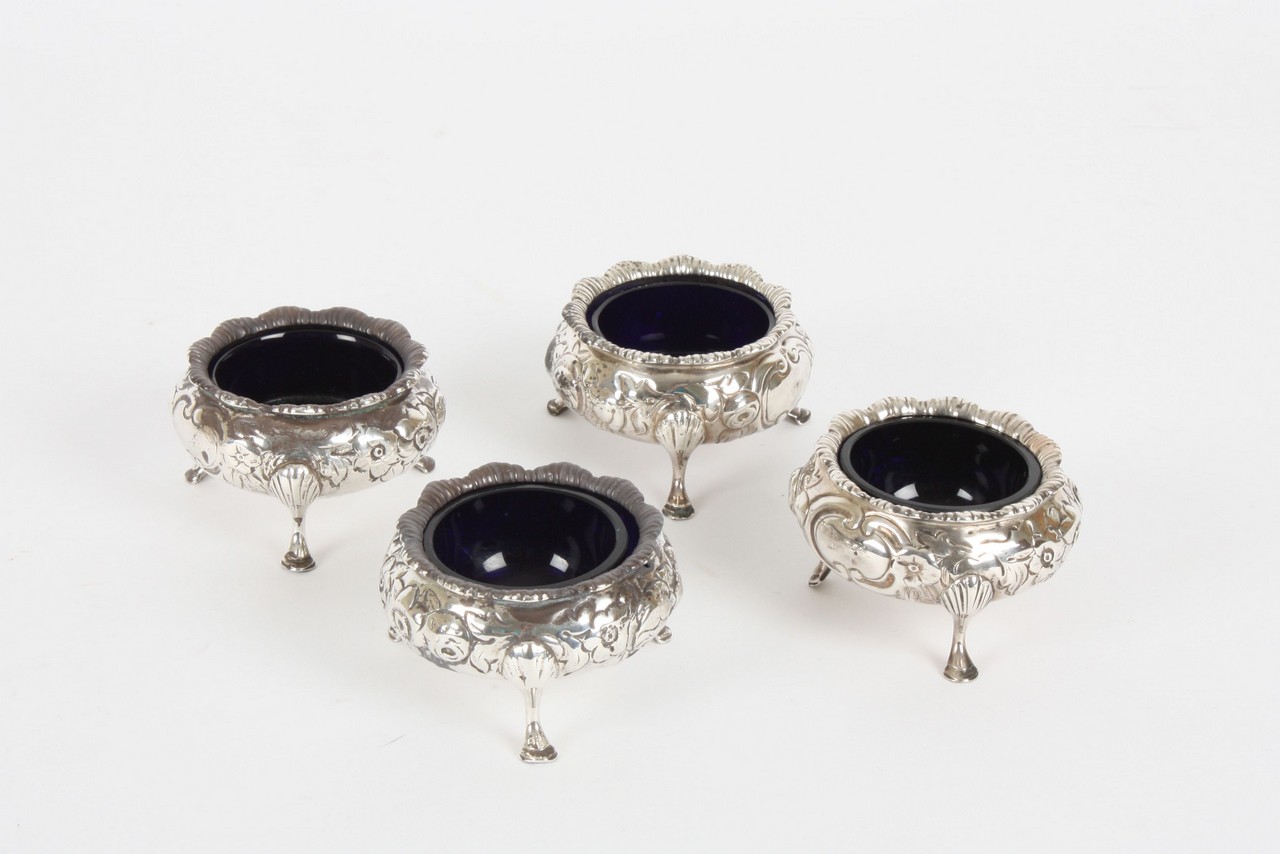 Four Victorian salts, hallmarked London 1871, with embossed floral decoration and complete with blue