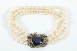 A three strand graduated pearl bracelet with sapphire and diamond clasp, the clasp with faceted