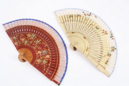 A pair of wooden fans, late 19th/early 20th century, both with pierced sticks and painted floral