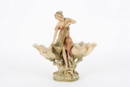 An Art Nouveau Royal Dux porcelain female figure, the figure holding a fish with two shell shaped