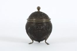 A Georgian silver gilt lined carved coconut tea caddy, circa 1800, finely carved with four