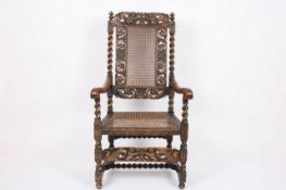 A James II style carved walnut open armchair, early 20th century, the top rail carved with a pair of