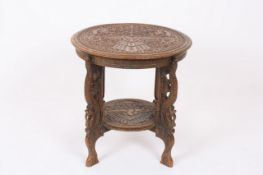 A Burmese carved hardwood occasional table, the circular top finely carved all over with scrolling