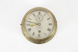 A brass bulkhead time piece, late 19th century, the 5 3/4 inch silvered dial stamped J.W.Benson,