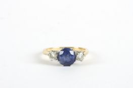 A three stone diamond and sapphire ring, with centre set sapphire in claw setting flanked by two