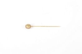 An unmarked yellow gold, diamond and chrysoberyl tie pin, early 20th century, with oval head and