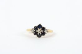A gold sapphire and diamond ring, with centre diamond and sapphires in flower setting flanked by