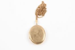 A 9ct yellow gold oval locket and chain the hinged front engraved with a kingfisher in flight.