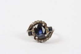 An Art Deco sapphire and diamond ring set with large central oval sapphire flanked either side by