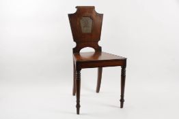 An early 19th century mahogany armorial hall chair?with shield shaped back and painted crest,