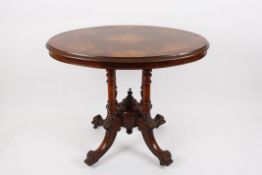 A Victorian figured walnut inlaid oval loo table?with quartered top and moulded rim, supported on