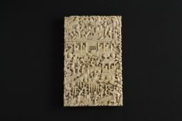 A 19th century Chinese Canton carved ivory card case finely carved all over with figures amidst a