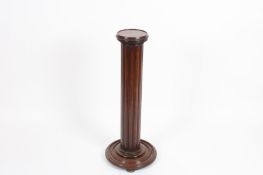 A Regency mahogany extending torchere stand with circular top, reeded column with vacuum action