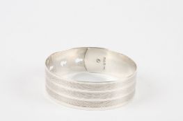 A Charles Horner silver bangle hallmarked Chester 1945, with buckle type clasp and engine turned