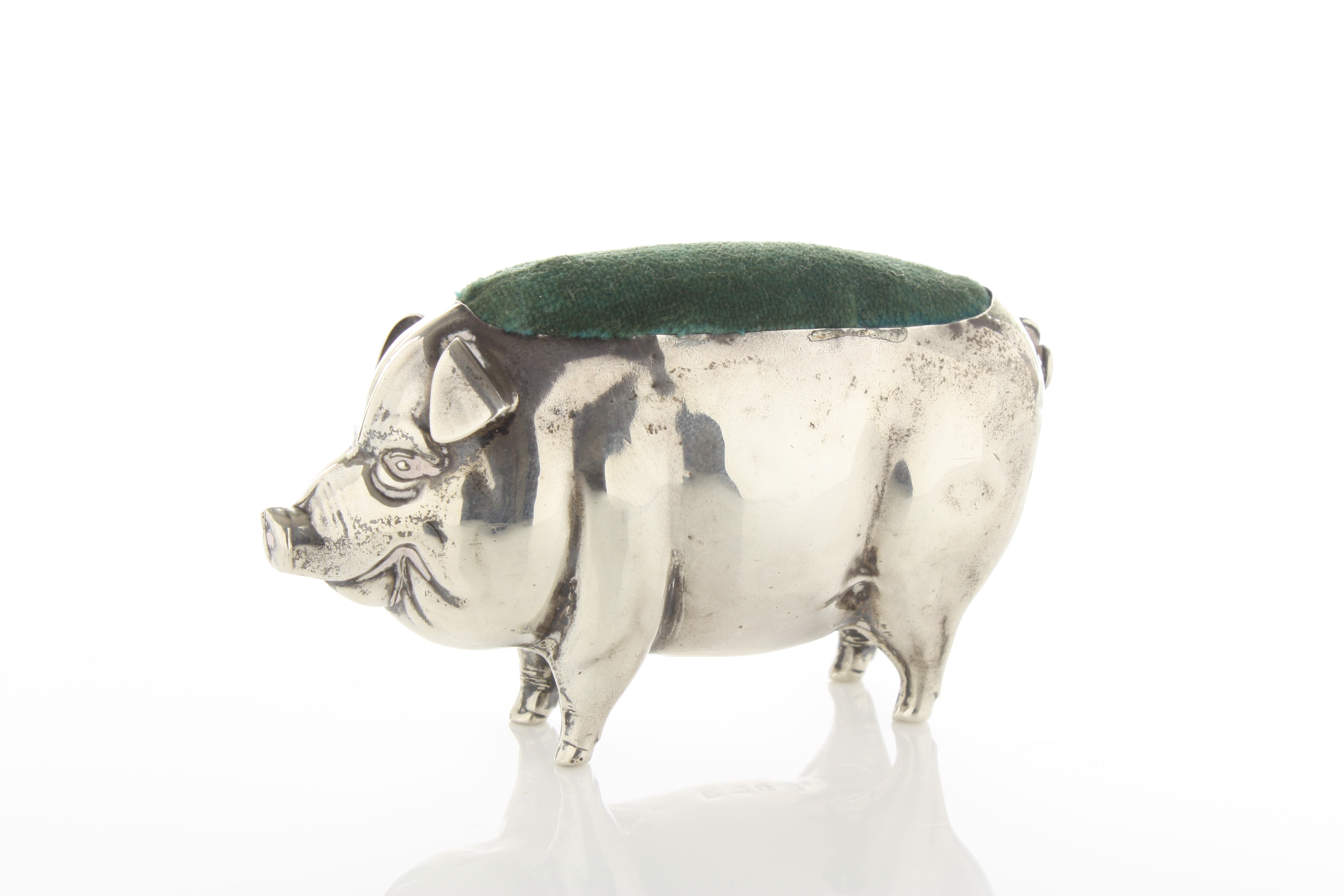A large silver pig shaped pin cushion hallmarked Birmingham, 1906 length 8.5cm With new cushion.