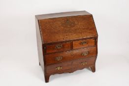 A Georgian oak bow fronted child`s bureau the front lifting down to reveal compartmented interior,