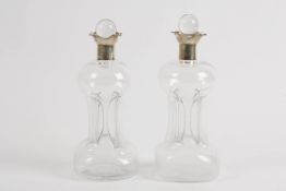 A pair of Victorian silver topped pinched glass decanters and stoppers hallmarked Birmingham 1898.