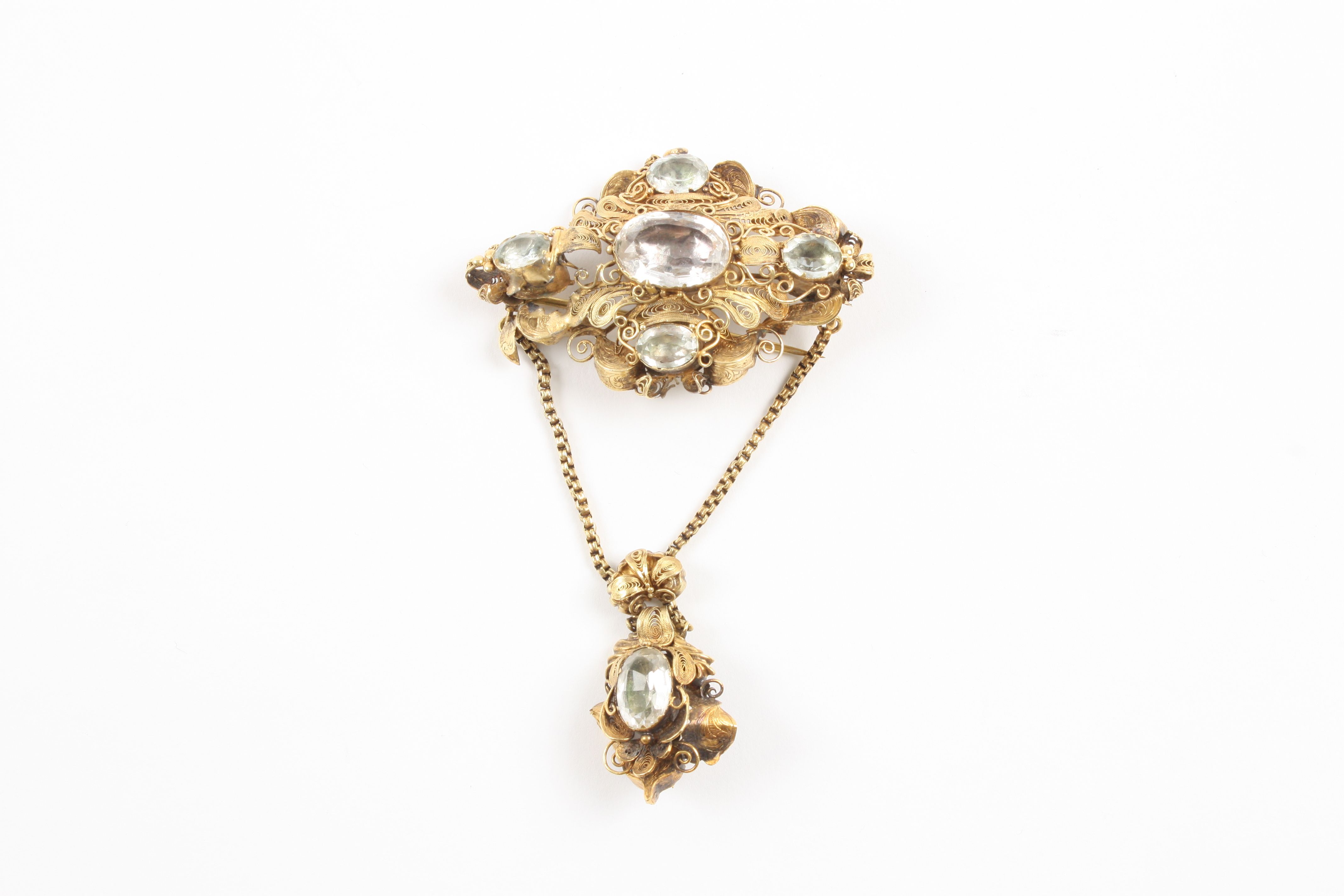 A Victorian yellow metal filigree brooch set with faceted oval stones, with further stone