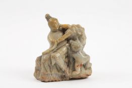 A 19th century Chinese carved soapstone figure depicting a woman seated holding a fan and wearing