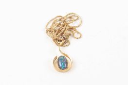 A silver gilt and doublet opal scrolled pendant set on a yellow metal chain stamped .750. Chain