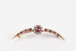 A ruby and diamond crescent brooch set with a central circular ruby surrounded by nine diamonds,