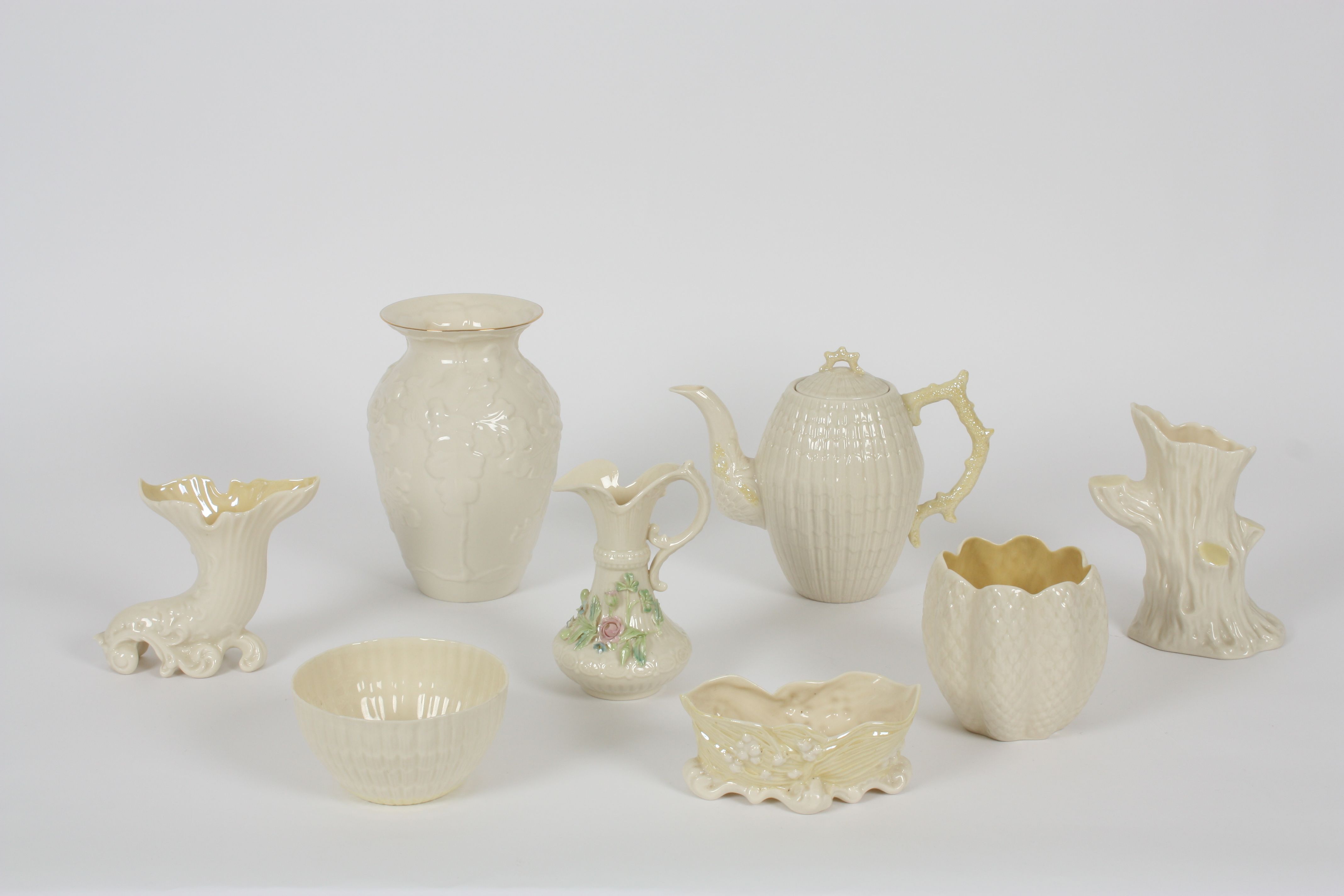 A collection of eight pieces of Belleek various dates  comprising a cream coffee pot decorated