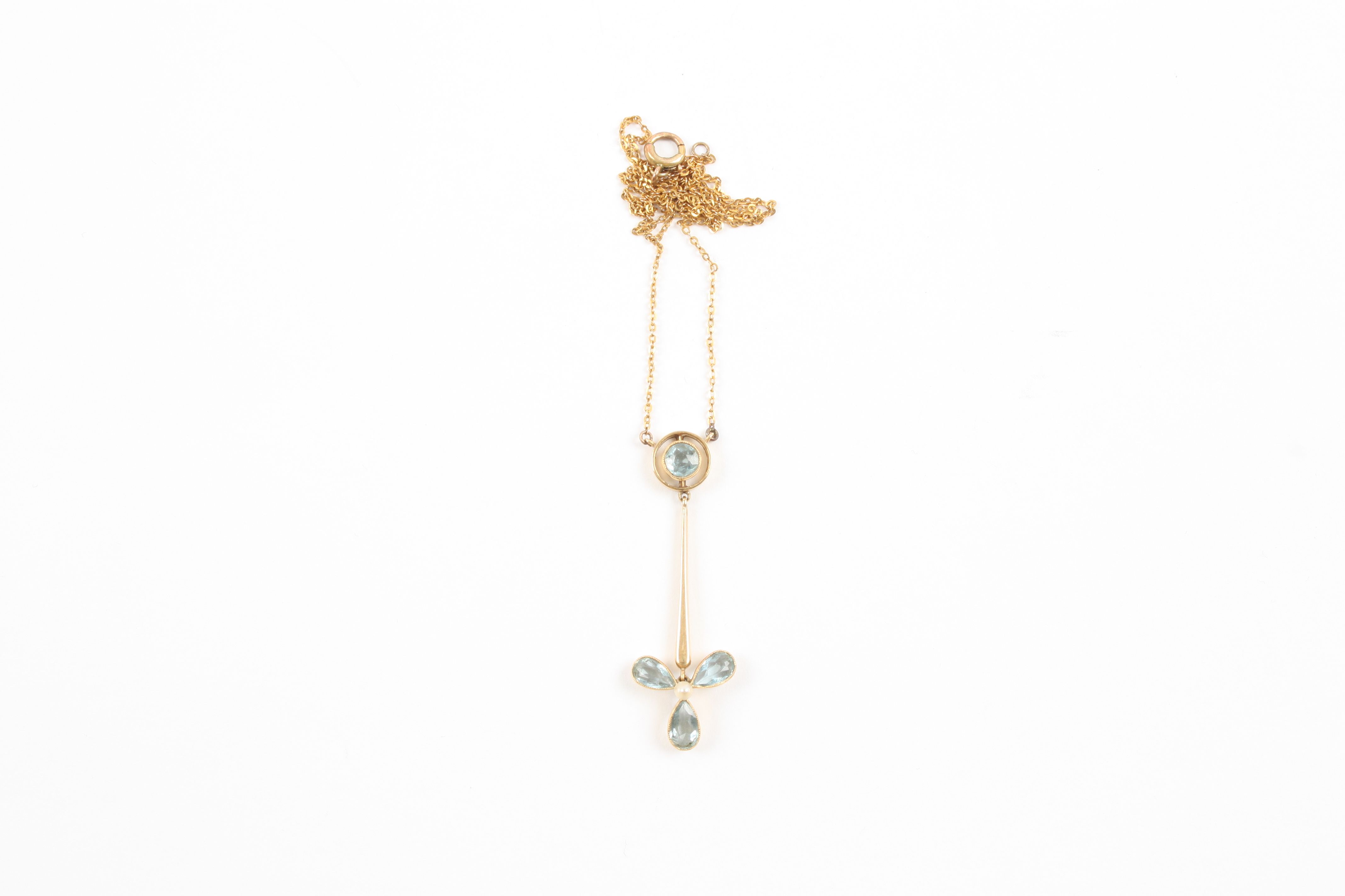 An Edwardian 9ct gold, aquamarine and seed pearl pendant the three petal flower head with seed pearl