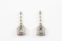 A pair of Art Deco design gold and diamond earrings each set with a central diamond of approximately
