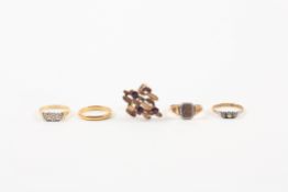 A group of five assorted gold rings comprising a 22ct gold wedding band, a 9ct gold and garnet