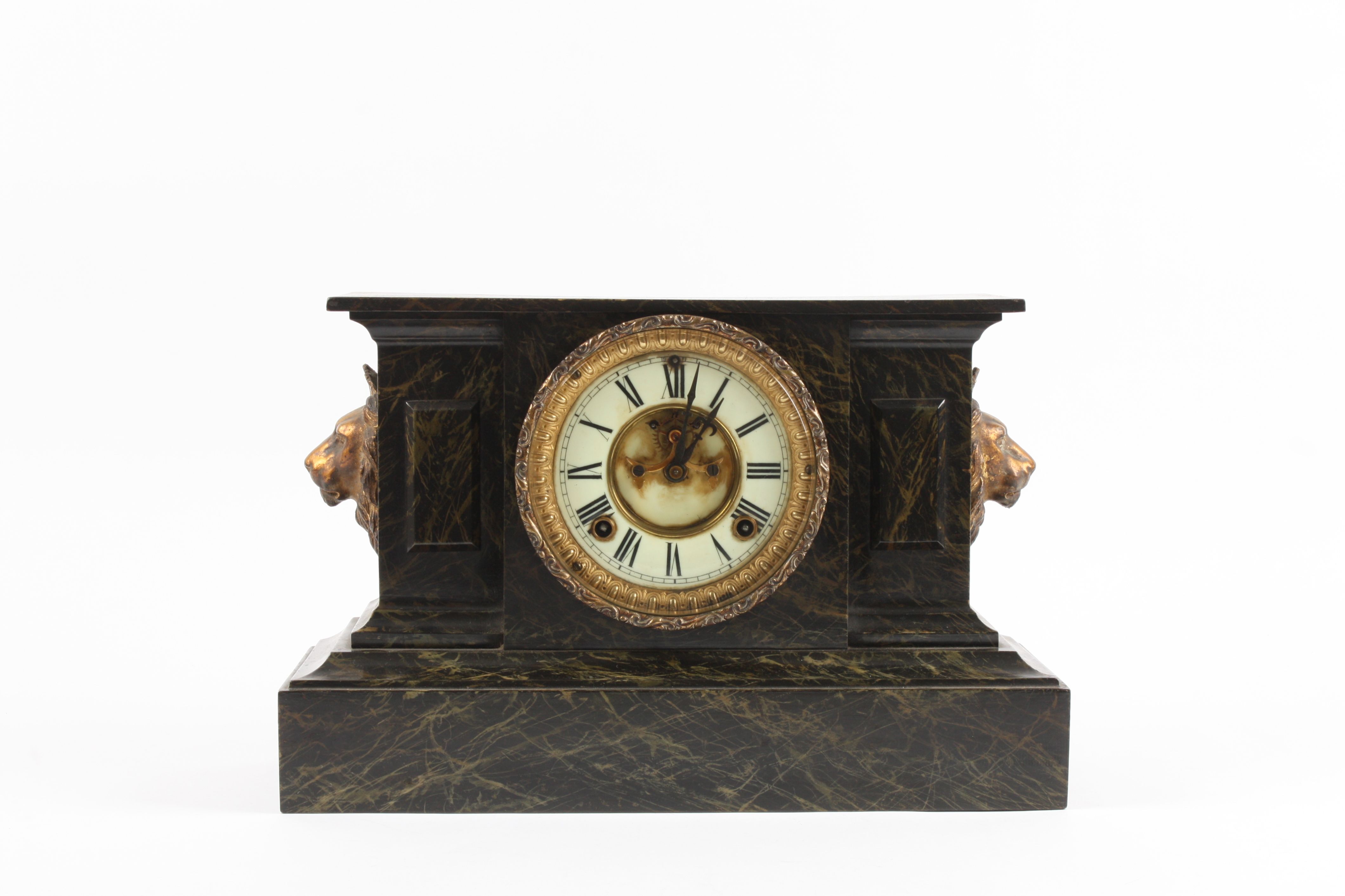 A Victorian simulated marble cast iron mantle clock crested with a spelter sphinx, the circular face