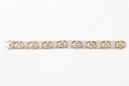 A Christian Dior style 9ct gold and diamond bracelet of yellow and white gold and set with `CD`