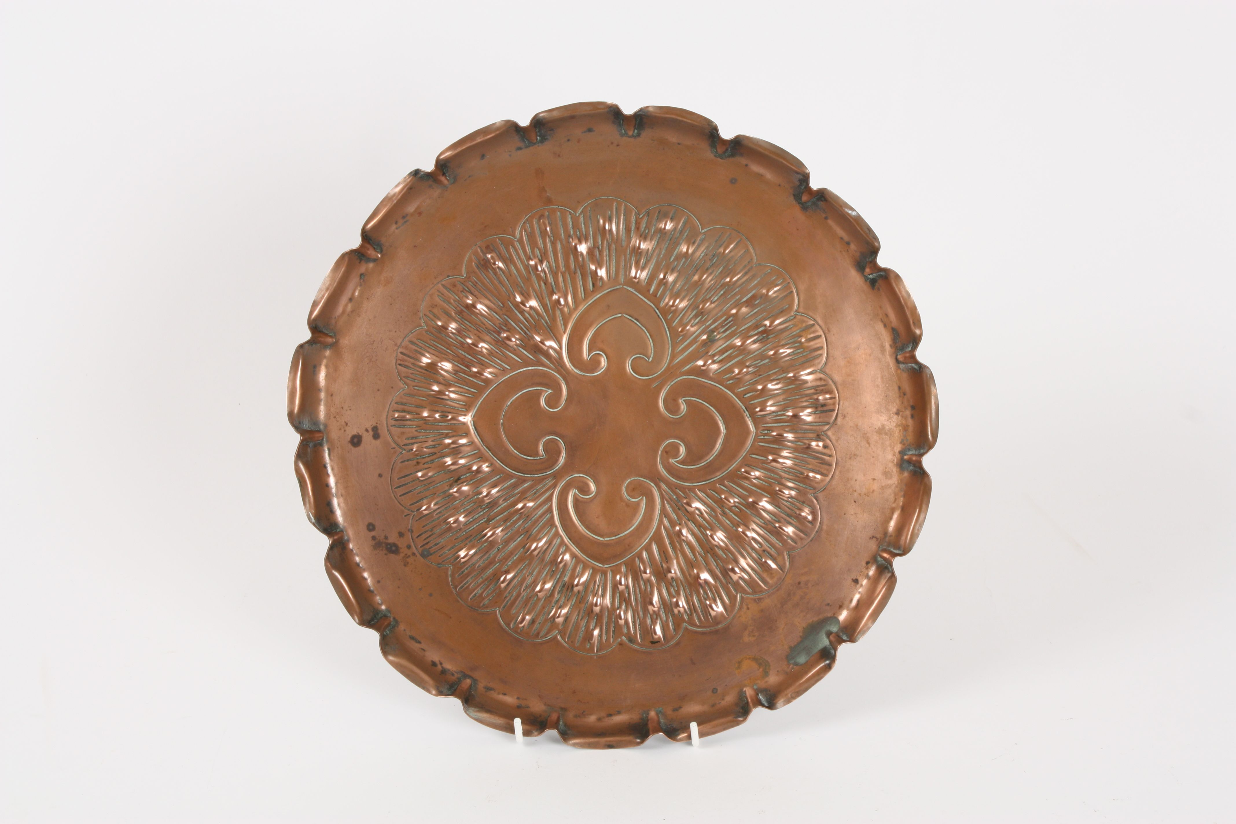 An Art Nouveau embossed copper tray by Townshend & Co. with pie-crust rim, the centre embossed