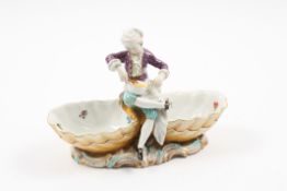 A late 19th century Meissen porcelain figural double salt formed as a boy seated with a mixing