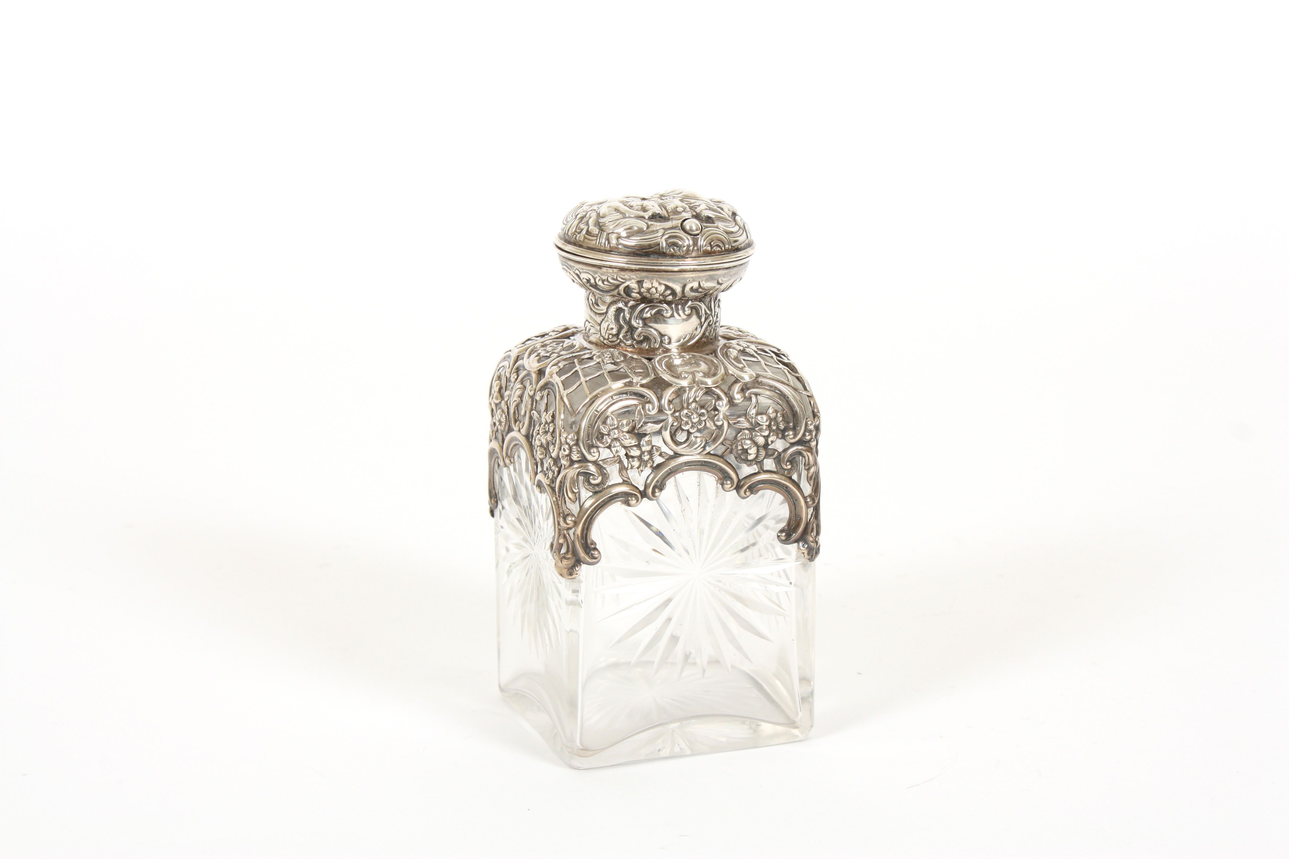 A Victorian silver and glass scent bottle by William Comyns hallmarked London 1897, the top embossed