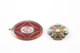 A 1930s copper and enamel oval brooch decorated with flowers together with a copper and enamel