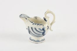 A mid 18th century Derby blue and white helmet-shaped cream boat with shell and dolphin moulded