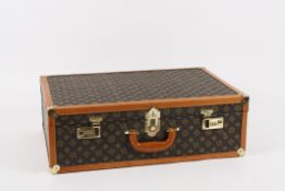 A Louis Vuitton style suitcase?with leather trimmed edges and fabric covering with lined interior.