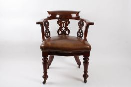 A Victorian mahogany desk chair?with curved back and scrolled arms, pierced back and side splats,