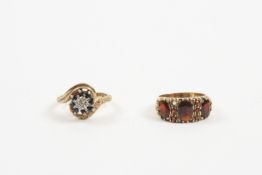 Two 9ct gold dress rings comprising: a gold and garnet three stone ring, and a spiral twist