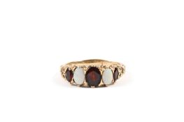A Victorian 9ct gold opal and garnet five stone ring with scrolled mount, stamped .375. 3.6 grams