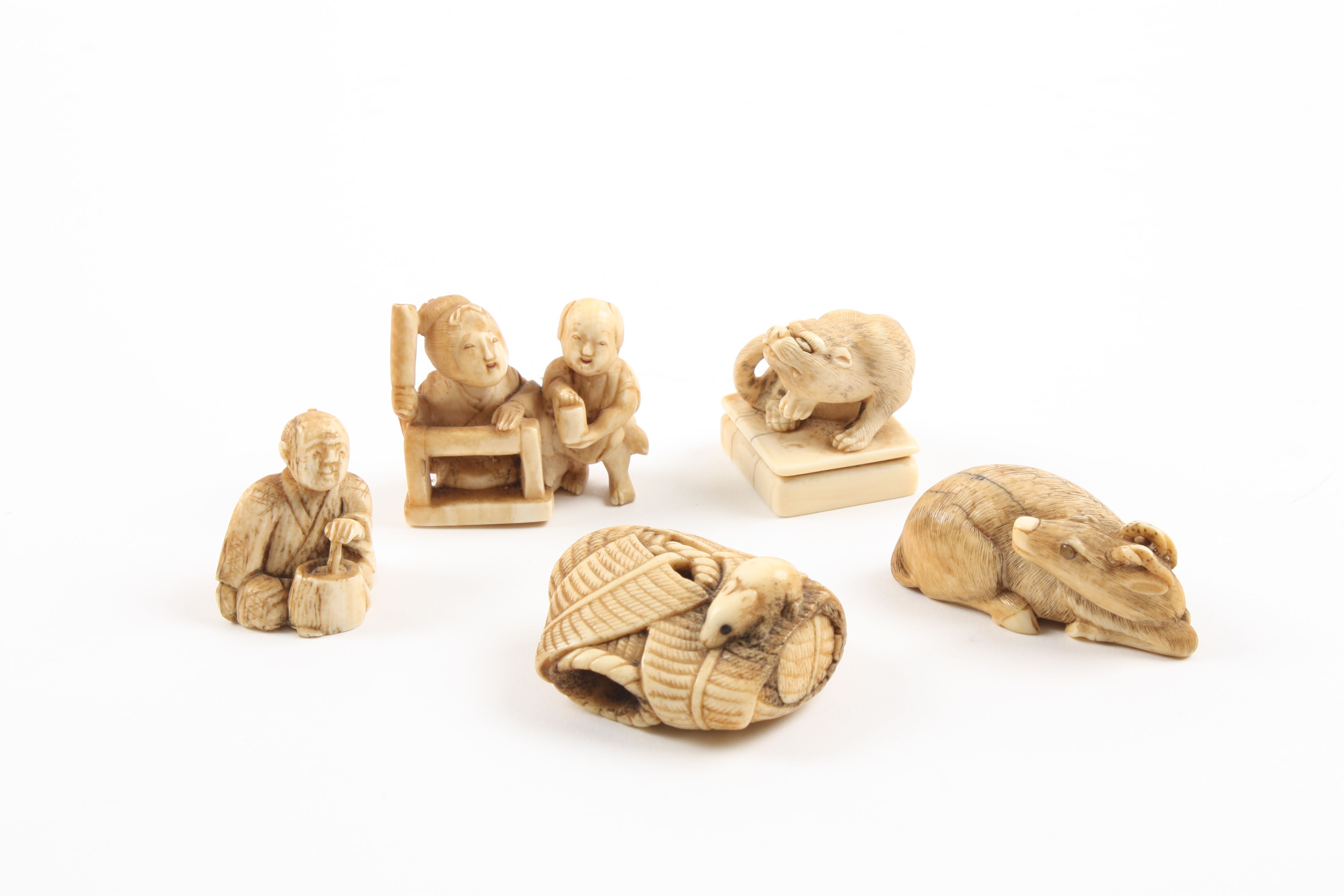 A group of four early 20th century Japaneese carved ivory Netsuke comprising a seated deer, a