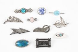 A collection of 11 silver, white metal and bakelite costume jewellery brooches of varying styles and