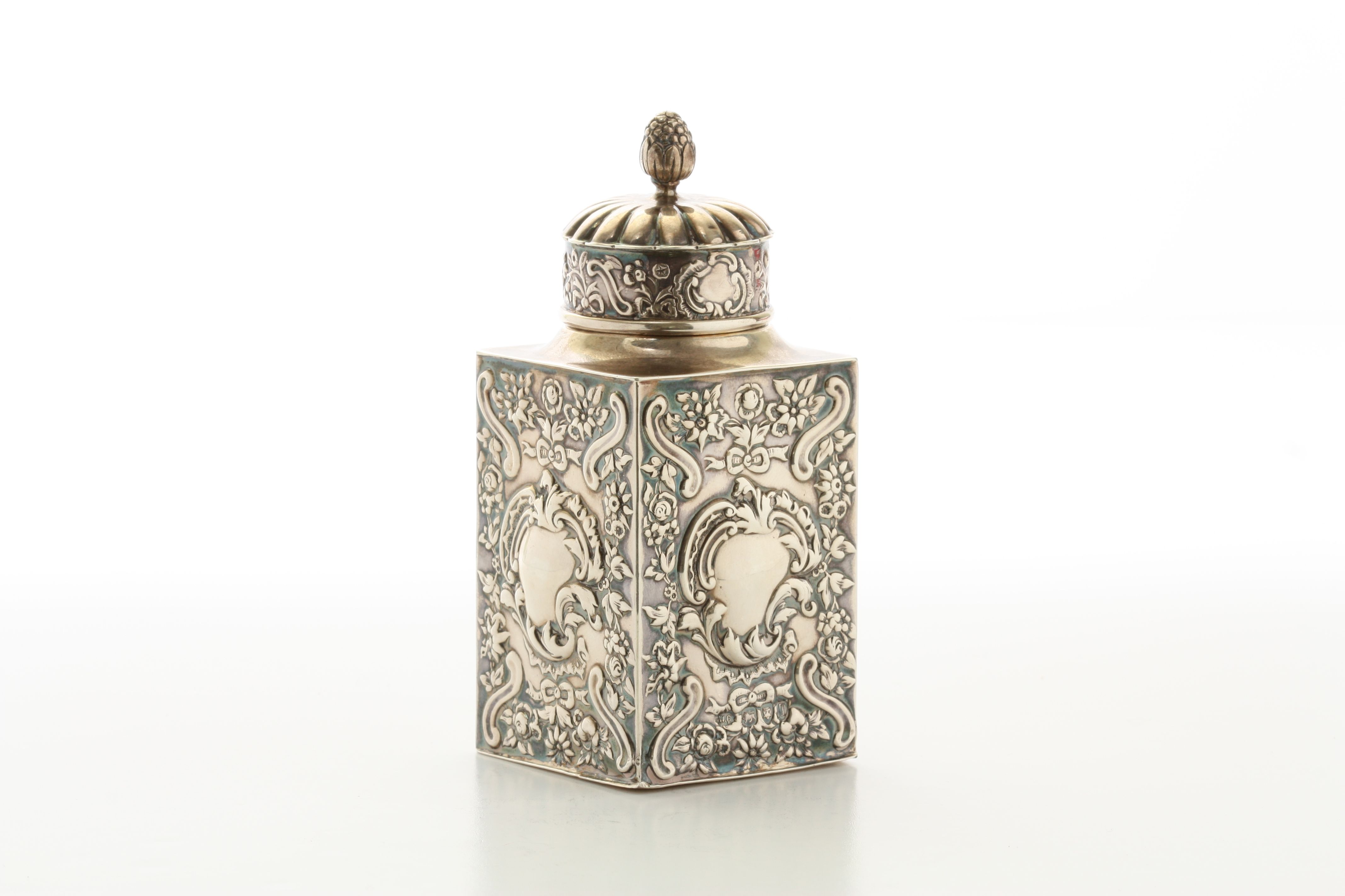 A Victorian repousse silver tea caddy by William Comyns hallmarked London 1894, the fluted lid