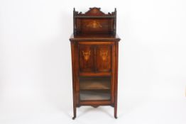 An Edwardian rosewood inlaid music cabinet?with shelf top, over a panel door with lower glazed